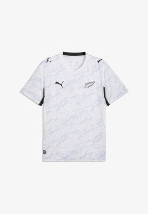 Maillot de sport blanc avec un motif tourbillonnant subtil, logo Puma noir sur la poitrine et les manches, et emblème de fougère noire sur le côté avant gauche.