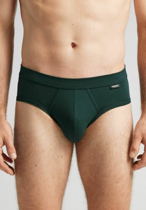 Dunkelgrüne Unterwäsche aus sanftem Material, mit einer unterstützenden Fronttasche, dickem Bund und minimalistischer Optik.