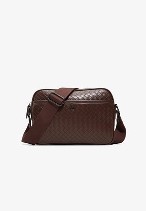 Sac bandoulière rectangulaire marron foncé avec texture en cuir tressé et large sangle en tissu réglable posée sur le devant.