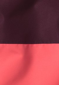 Tessuto colorato a blocchi con una sezione superiore di un borgogna scuro e una sezione inferiore di un rosa corallo, caratterizzato da una texture liscia e opaca.