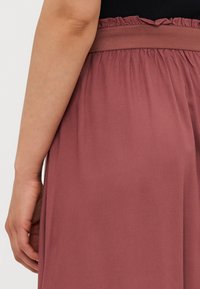 Malinová růžová sukně s nařaseným elastickým pasem a hladkým, lehkým materiálem. Vystavuje splývavý design a jemnou texturu.