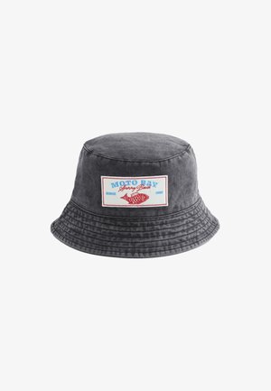 Donkere grijze bucket hat met gestikte rand, voorzien van een rechthoekige patch met een rode vis en blauwe en rode tekst waarop "MOTO BAY Sunny Beach" staat.