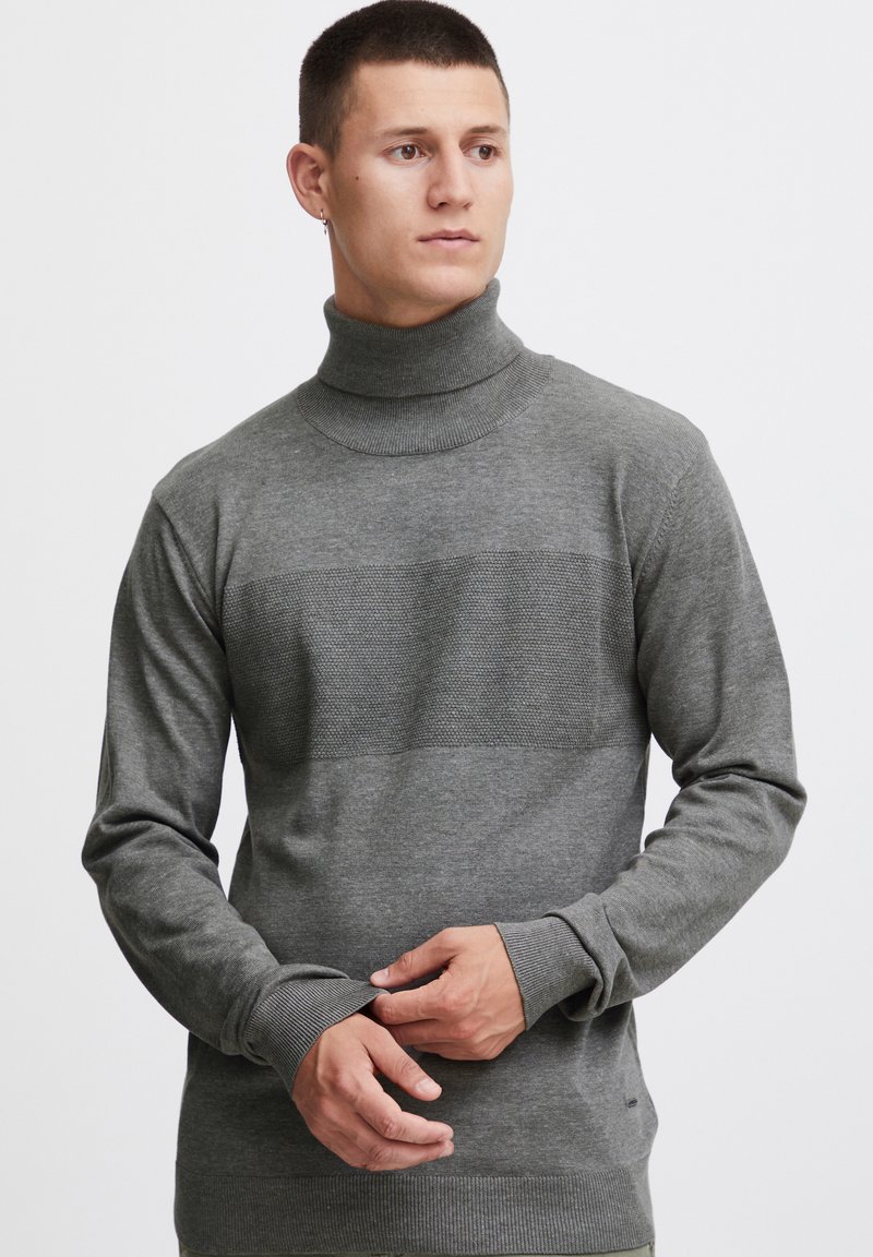 Gray turtleneck sweater made of knitted fabric, featuring a textured horizontal band across the chest and ribbed cuffs.