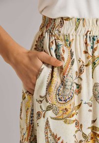 Rock mit elastischem Bund aus leichtem Stoff, versehen mit einem mehrfarbigen Paisley-Muster. Enthält seitliche Taschen und ein legeres Schnittdesign.