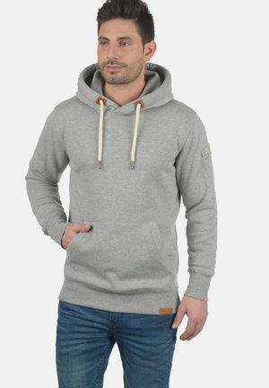 Grauer Baumwoll-Hoodie mit einer vorderen Kängurutasche, verstellbarem Kapuzenzug mit cremefarbenen Kordeln und einem Lederakzent am Saum.