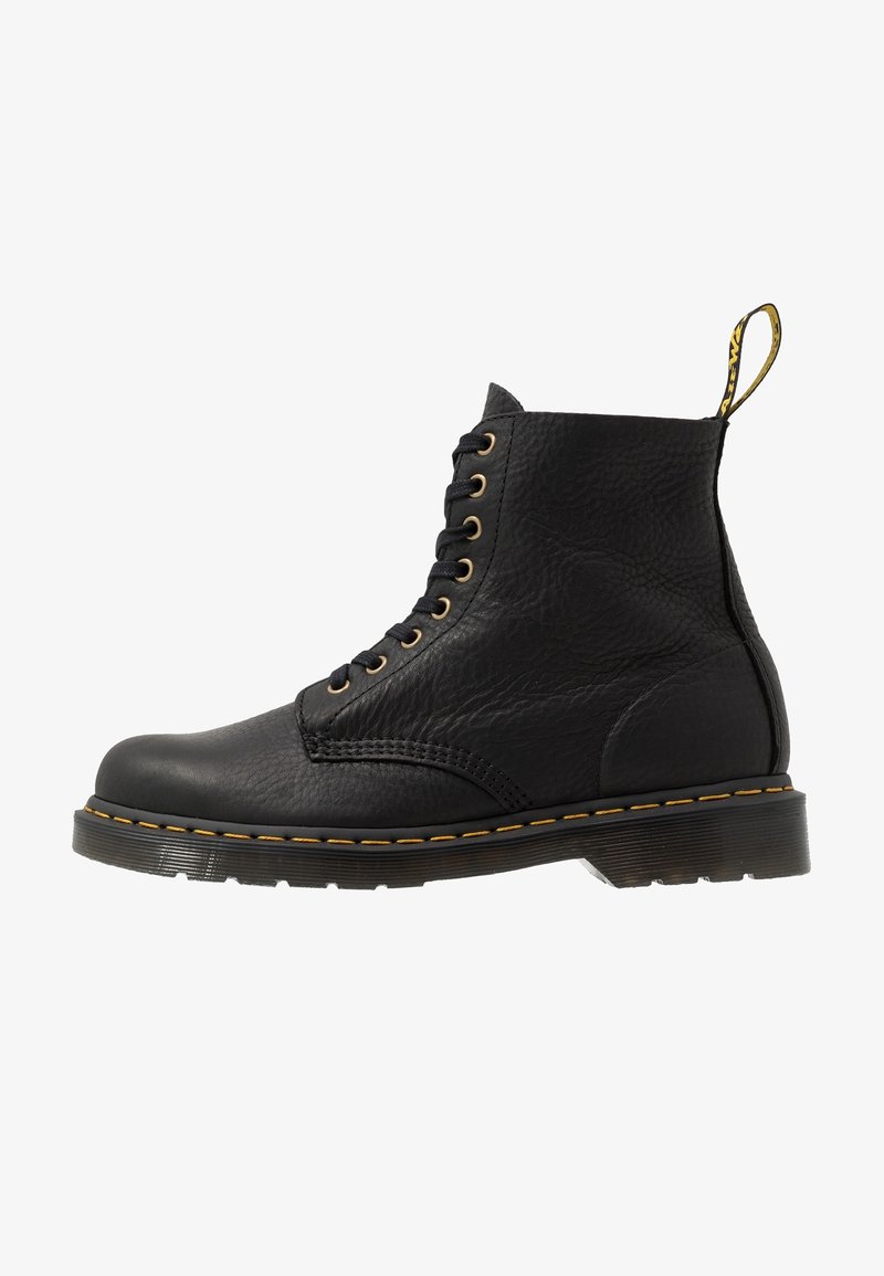 Bottines en cuir noir à lacets avec des coutures jaunes et un tirant de marque à l'arrière.