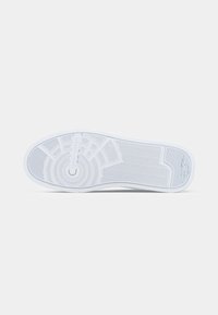 Talpa de sneaker alb cu un model în formă de pește, accente circulare și zone texturate pentru aderență și flexibilitate. Finisaj neted.