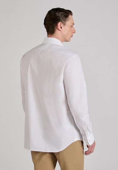 Witte lange mouwen blouse gemaakt van lichtgewicht stof, met een klassieke kraag, rechte zoom en knoopmanchetten. Glad oppervlak.