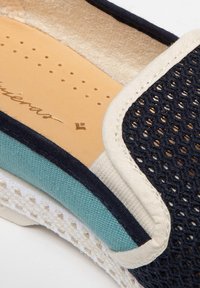 Canvas instap schoen met een marineblauwe mesh bovenkant, licht aqua zijpaneel en crèmekleurige accenten. Inclusief geperforeerde binnenzool voor ademend vermogen.