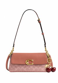 Sac bandoulière rose avec fermoir doré en forme de "C", breloque cerise, sangle ajustable et panneau en tissu à motif discret.