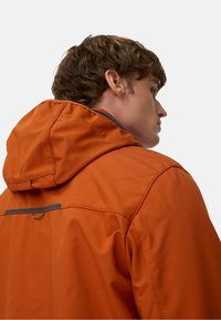 Orange waterproof jacket with a hood, featuring textured fabric, a black accent strip on the back, and a smooth finish.
