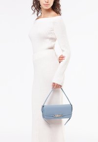 Borsa a tracolla in pelle azzurro chiaro con design strutturato, caratterizzata da un accento dorato sul davanti e una tracolla staccabile.