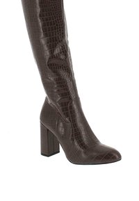 Bota alta de imitación cuero marrón con textura de cocodrilo, punta puntiaguda y tacón alto ancho. Acabado liso y diseño elegante.