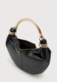 Crna kožna torba s ručkom u zlatnoj boji, zatvaranjem na patentni zatvarač i dekorativnim zlatnim prstenovima na pričvršćenjima ručke.