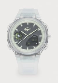 Clear watch featuring a round face with black texture and luminescent accents, digital display, and transparent silicone strap.