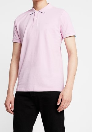 Polo rose clair avec un col à revers, doté de trois boutons et de manches courtes. Agrémenté d'un bord uni aux poignets.
