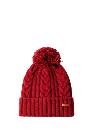 Gorro de invierno rojo tejido con patrones trenzados, puño acanalado doblado, gran pompón en la parte superior y pequeña etiqueta marrón en el puño.