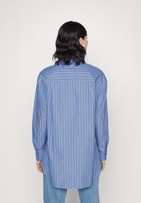 Blau gestreiftes Langarmhemd mit entspannter Passform, mit geknöpften Manschetten und abgerundetem Saum, aus leichtem Stoff gefertigt.