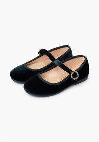 Ballerine in velluto nero con punta arrotondata, suola piatta e cinturino in velluto con un accento circolare decorativo. Tessuto liscio.
