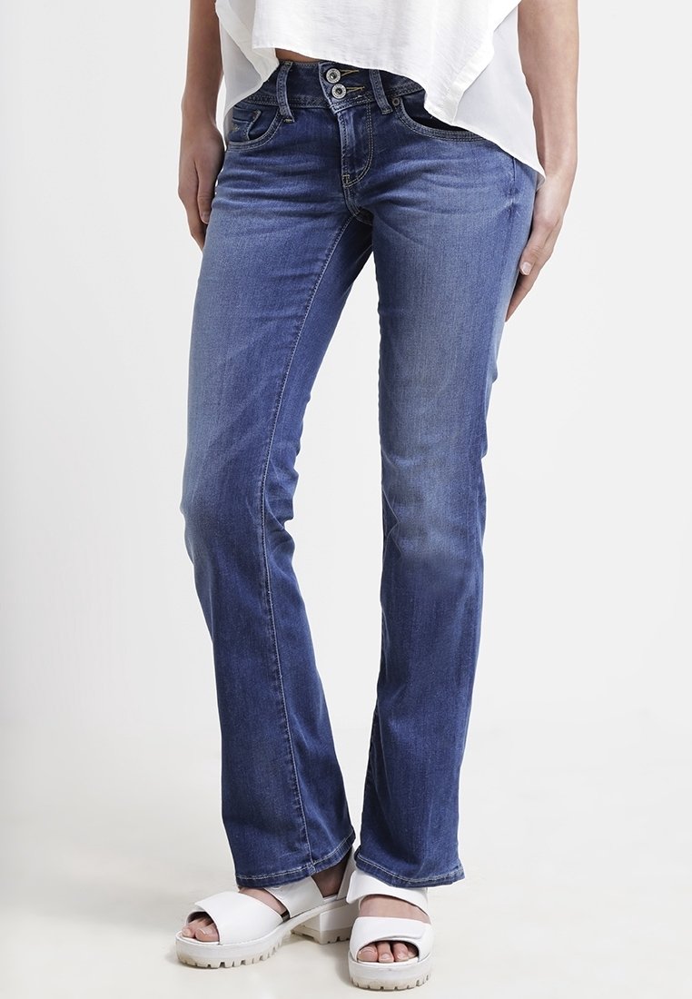 Blå denimjeans med rak passform, med tryckknapp och två framfickor. Bärs med vita platåsandaler.