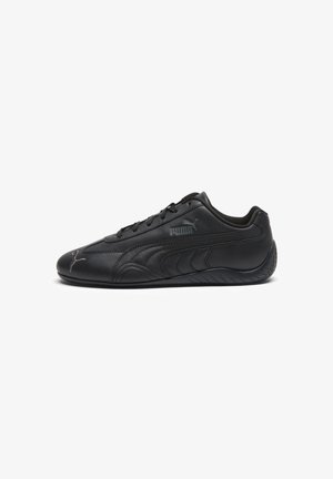 Zapatilla negra de perfil bajo Puma con parte superior de cuero elegante, logo lateral de Puma y cierre de cordones, mostrada de perfil sobre fondo blanco.
