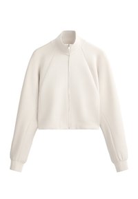 Vaalean beige lyhyt takki, jossa on korkea kaulus, etuvetoketju ja ribbikuvio. Varustettu raglan-hiemeillä ja sivutaskuilla.