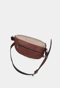 Borsa a tracolla rossa e beige con forma arrotondata, realizzata in pelle, dotata di una tasca frontale con zip e una tracolla staccabile. Il testo in cima recita "stile con attitudine."