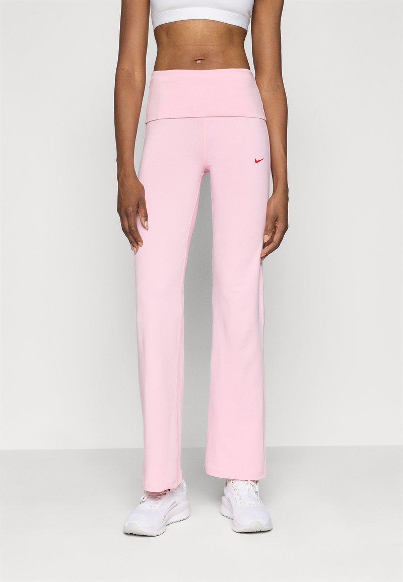 Pantaloni della tuta a vita alta, di colore rosa chiaro, con una consistenza morbida, gambe svasate e un piccolo logo Nike rosso in vita.
