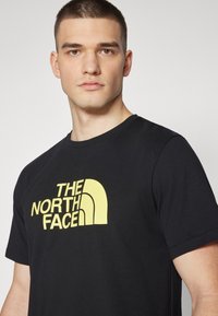 The North Face EASY TEE - Camiseta estampada - black/sun yellow