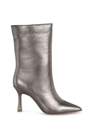 Bottine argentée métallique avec un bout pointu, finition en cuir lisse et un talon haut élancé. Design épuré avec peu de couture visible.