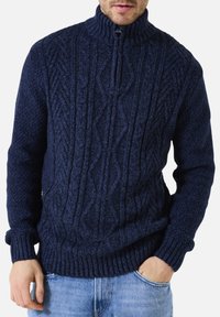 Dunkelblaues Kabelstrickpullover mit hohem Kragen und halbem Reißverschluss. Dicke Rippbündchen und Abschlüsse sorgen für Textur. Aus einer Wollmischung gefertigt.