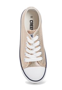 Sneaker dorata metallizzata con lacci bianchi, punta in gomma bianca e design a profilo basso. Presenta un upper in tessuto e suola di contrasto blu navy.