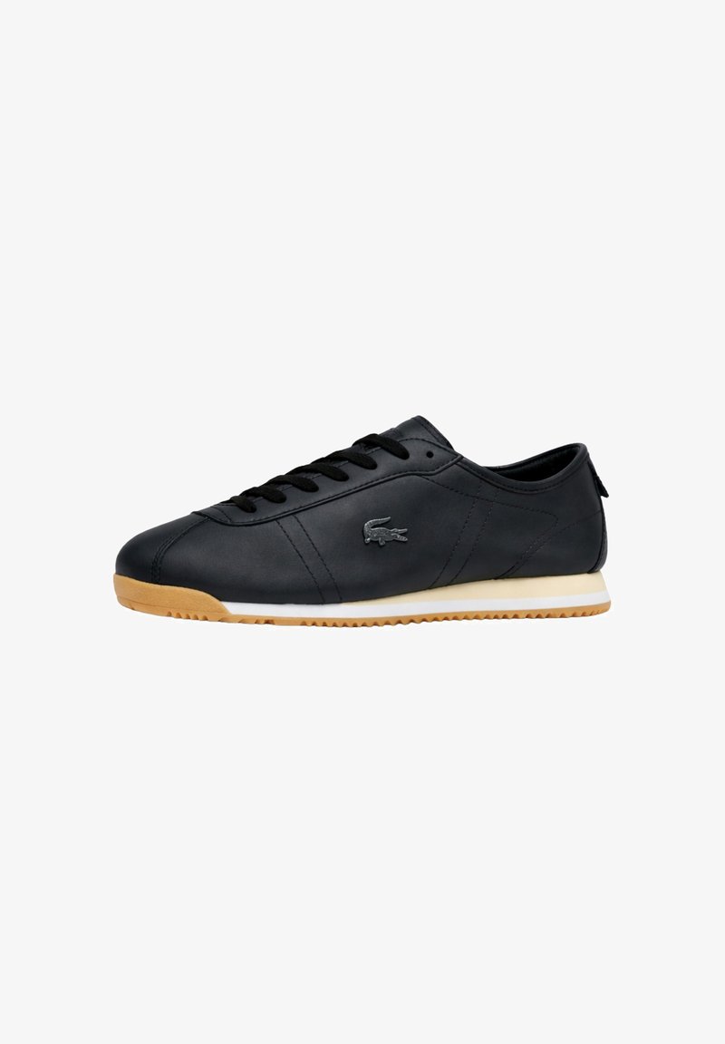 Baskets basses en cuir noir avec lacets noirs, semelle extérieure gomme, bande blanche sur la semelle intermédiaire et logo crocodile argenté sur le côté.