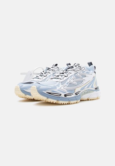 Ζευγάρι λευκά και ανοιχτό μπλε αθλητικά παπούτσια με μαύρα σχέδια βελών, λεπτομέρειες από δίχτυ και παχιές υφασμάτινες μπεζ σόλες, τοποθετημένα δίπλα-δίπλα.