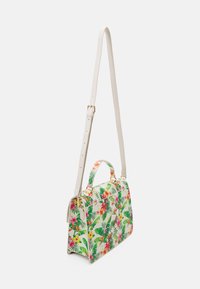 Petit sac à main avec une longue bandoulière beige ajustable, une poignée courte et un motif floral tropical vibrant avec des feuilles vertes et des fleurs roses et jaunes.