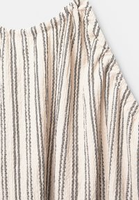 Tessuto chiaro con strisce verticali nere e grigie, caratterizzato da una texture arricciata e dettagli raccolti sulle spalle.