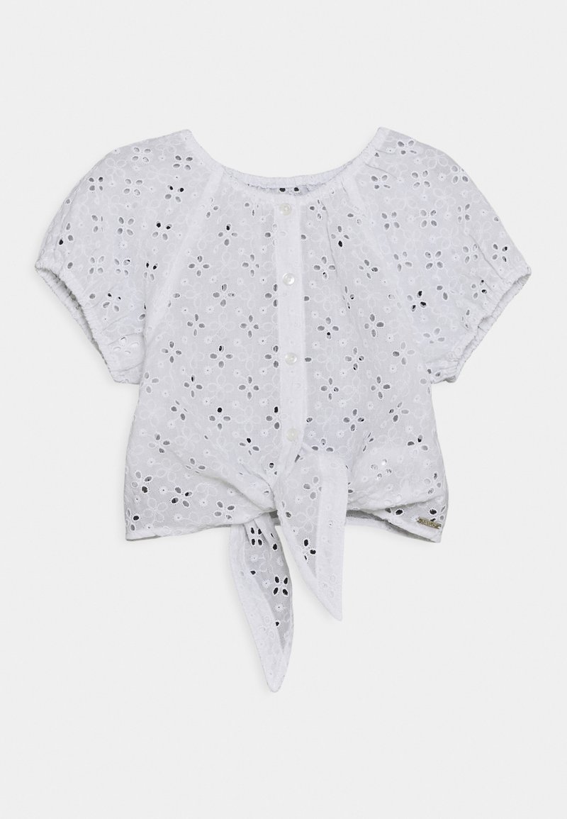 Blouse blanche à manches courtes avec un motif floral en œillets, boutons avant et un nœud noué à l'ourlet.