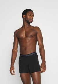 Boxers ajustados de algodón negro con una suave cinturilla elástica que presenta la marca "JBS UNDERWEAR". El ajuste es ceñido, diseñado para comodidad y soporte.