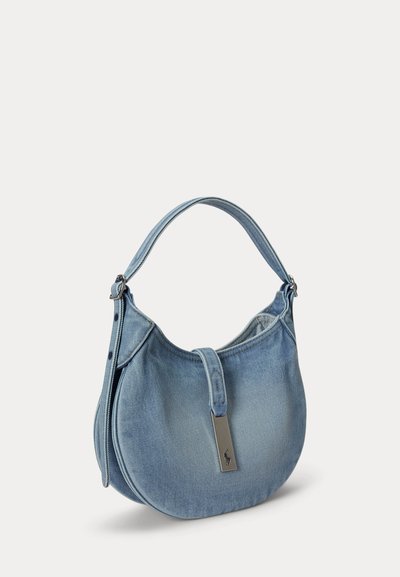 Világoskék farmer hold alakú kézitáska rövid fogóval és egy kis dombornyomott logót tartalmazó fém címkével.