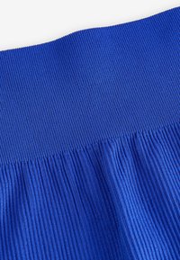 Tela azul acanalada con un patrón texturizado. El borde superior es liso, que pasa a una tela fruncida abajo. Color intenso con un acabado uniforme.