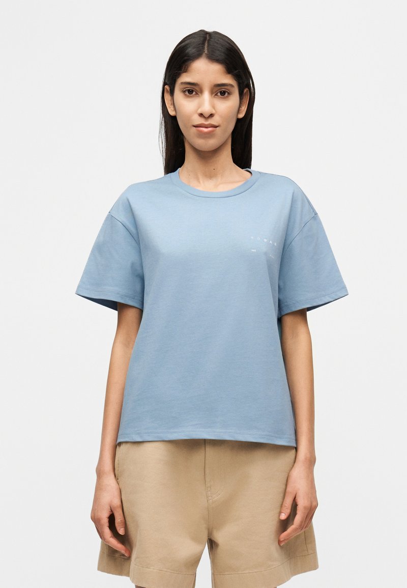 Μπλε βαμβακερό μπλουζάκι με κοντά  μανίκια, λαιμόκοψη τύπου crew και διακριτική σήμανση στο αριστερό μέρος. Λείο ύφασμα και άνετη εφαρμογή.