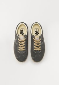 Grå mockaskor med kontrasterande beige snören, rund tå och vit sömnad. Har ett varumärkestagg på tungan.