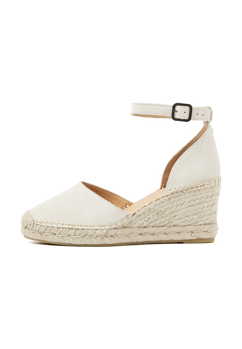 White suede wedge sandal with an ankle strap, braided jute sole, rounded toe, and a textured finish.