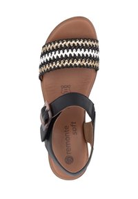 Black and tan sandal with a woven strap featuring black, white, and gold fibers. Leather insole and adjustable buckle on the ankle strap.