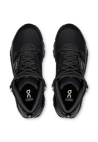 Paar schwarze wasserdichte Cloudrock-Wanderschuhe mit Schnürverschluss, von oben auf weißem Hintergrund betrachtet.