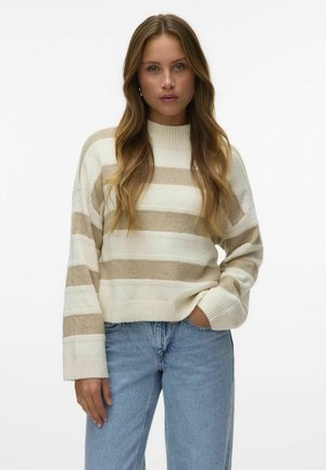 Cremiger und beige gestreifter Strickpullover mit hohem Kragen und gerippten Bündchen, getragen mit hellblauen Jeans. Weicher Stoff und lässige Passform.
