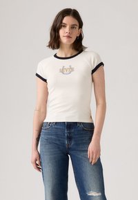 Hvid tætsiddende t-shirt med marineblå ringede ærmer, der har "Levi's" logo i gult og blåt broderi på brystet.