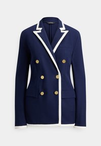 Blazer azul-marinho com abotoamento duplo e acabamento branco nas lapelas, punhos e bainha, apresentando seis botões dourados e bolsos frontais com aba.