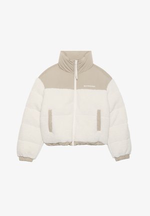 Lyhennetty takki, jossa on beige yläosa ja valkoinen pörröinen fleece-alareuna. Varustettu etuvetoketjulla, kahdella sivutaskulla ja korkealla kauluksella.