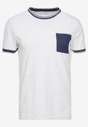 Biała koszulka z krótkim rękawem, z granatowym wykończeniem przy dekolcie typu crew neck, pasującymi mankietami na rękawach oraz granatową kieszenią na lewej stronie klatki piersiowej.